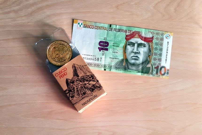 Billete de 10 nuevos soles peruanos y moneda conmemorativa de Machu Picchu